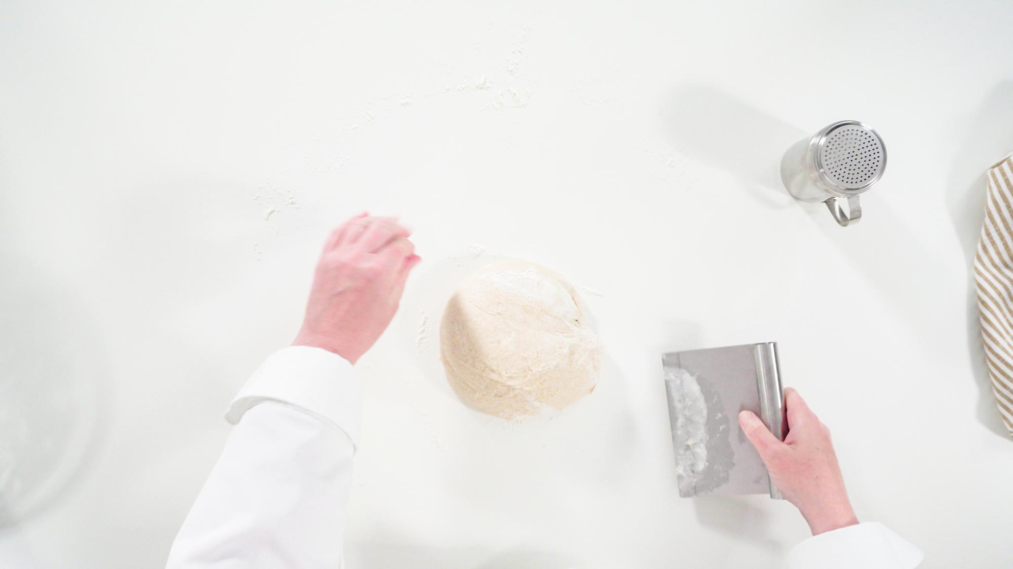 Chef in cucina che mostra una tecnica di impasto
